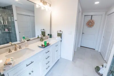 Completed bathroom remodel by R2F Construction in Boise, Idaho — white double vanity, quartz counters, and tiled walk-in shower